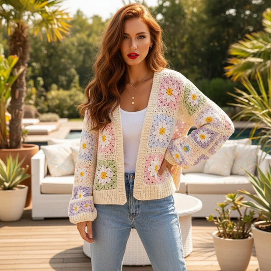 Daisy crochet cardigan worn by a model outdoors in a vibrant garden setting, showcasing floral patterns and soft knit texture.